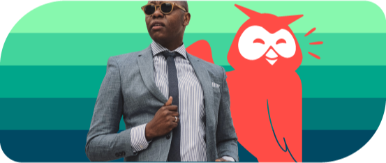 A man in a suit with sunglasses in posing beside Owly